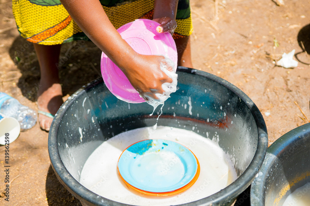 Obraz premium hand of african woman while washing dishes