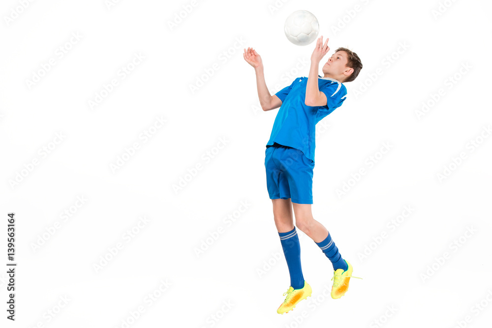 Young boy with soccer ball doing flying kick