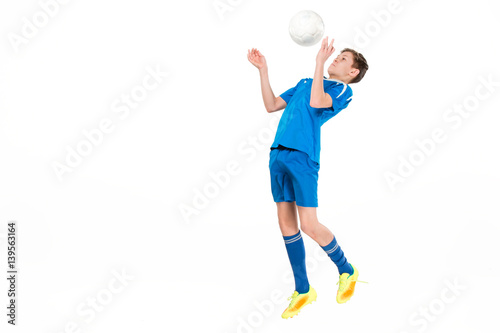 Young boy with soccer ball doing flying kick © master1305
