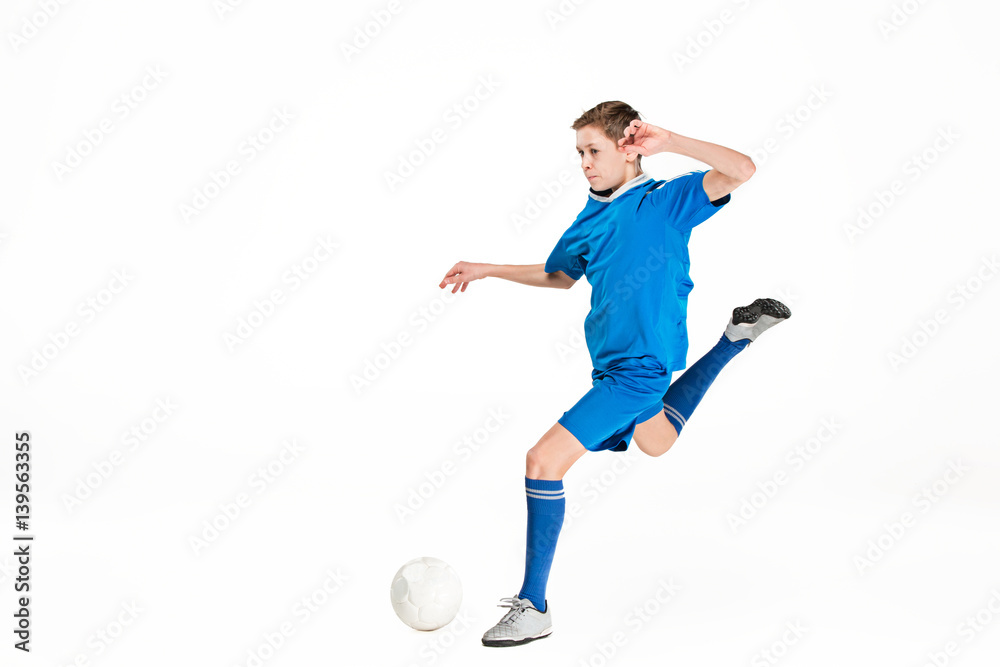 Fototapeta premium Young boy with soccer ball doing flying kick