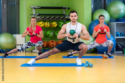 Kettlebells swing exercise man and woman workout at gym