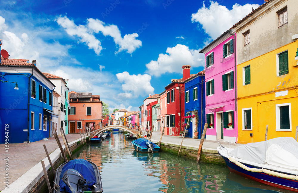 multicolored houses over canal with boats, street of Burano island, Venice, Italy