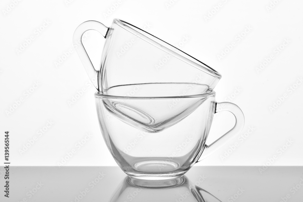 Two transparent glass cups on the white background