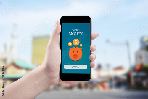 Woman hand holding the phone with saving money screen