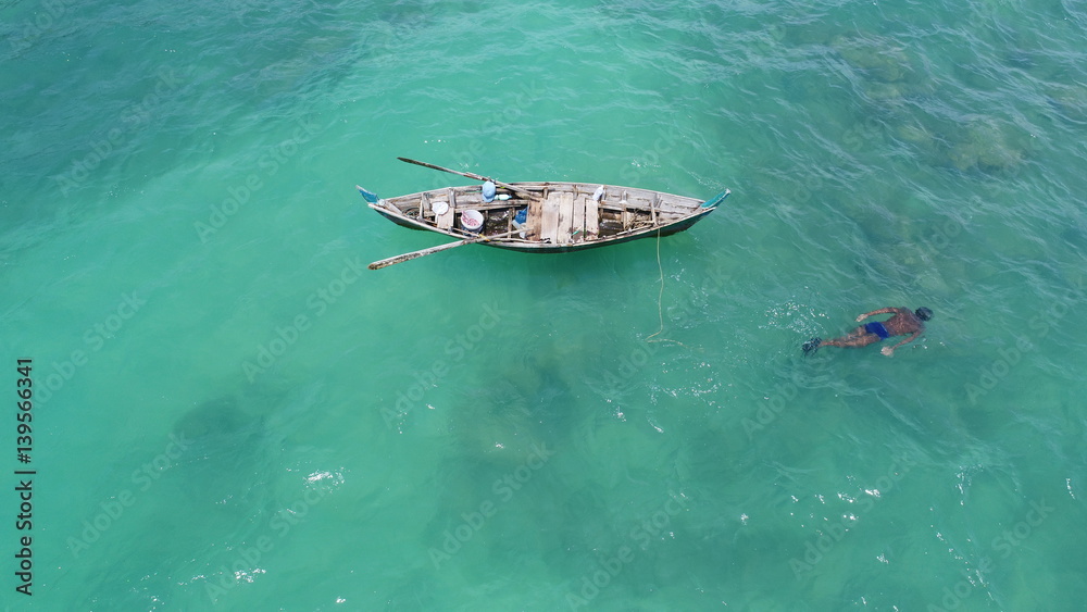 Naklejka premium Aerial top view of boat on the sea and fisherman in the water hunting