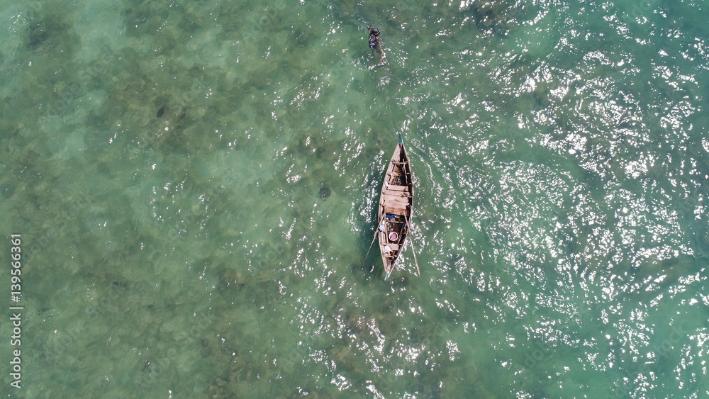 Aerial view of boat on the sea and fisherman in the water hunting