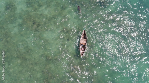 Aerial view of boat on the sea and fisherman in the water hunting