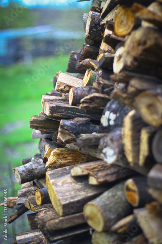 Fototapeta Naklejka Na Ścianę i Meble -  Stacked firewood harvested for winter. Rural landscape. Blur bokeh background