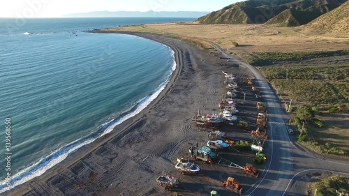 Aerial view of fishing boats and tractors on Ngawi beach, New Zealand photo