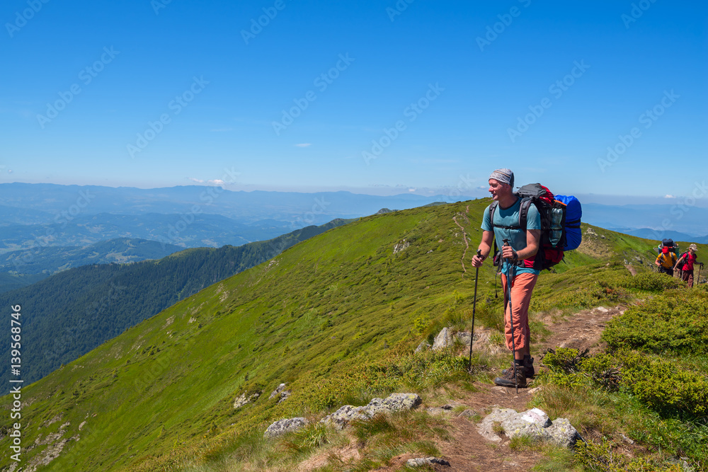 Obraz premium Friends - men and boy with backpacks go on a mountain trail