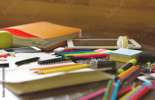 Colorful assortment of school supplies on table. Selective focus and small depth of field.