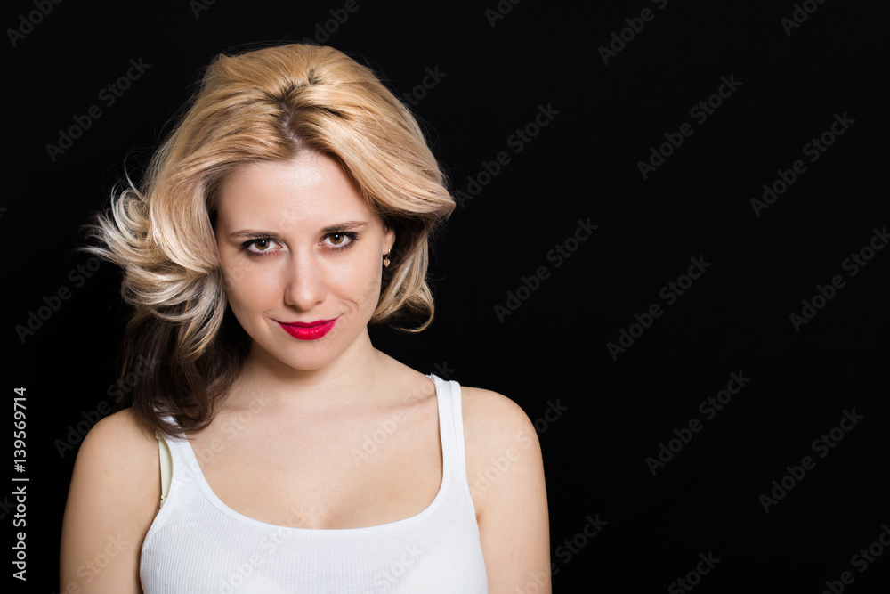 Woman with blonde curls and red lipstick on a dark background closeup Woman with blonde curls and red lipstick on a dark background closeup