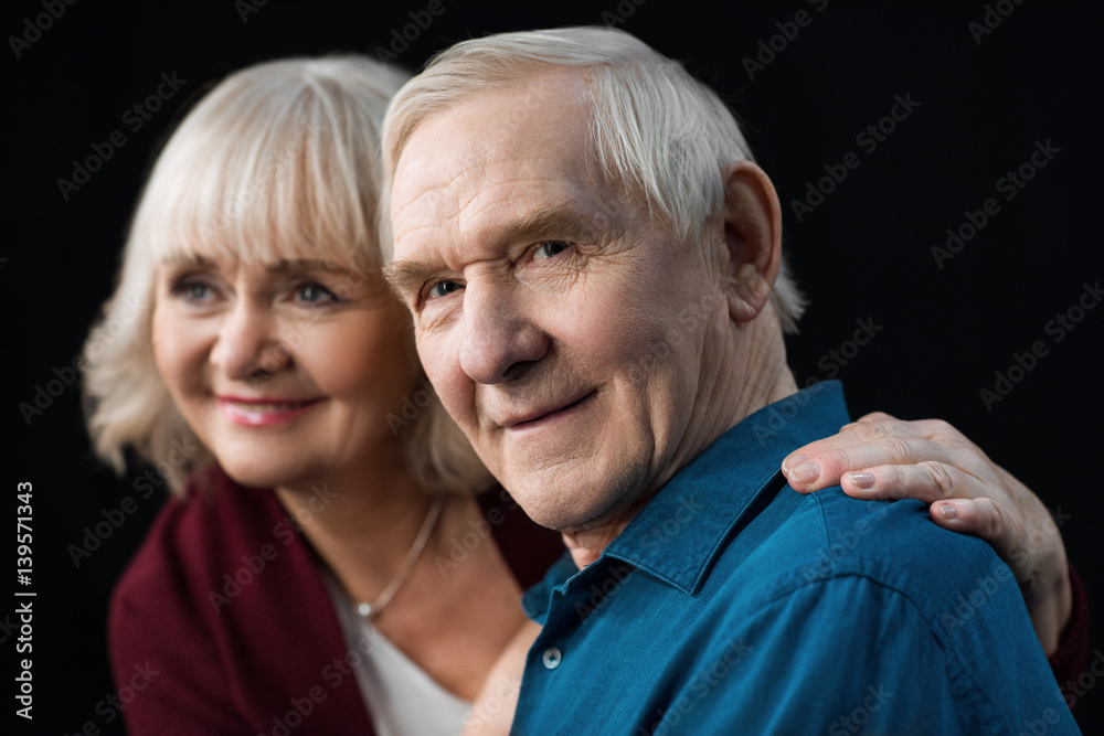 portrait of smiling senior man and woman on black portrait of smiling senior man and woman on black