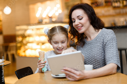 Wallpaper Mural Young woman showing something interesting to her daughter in touchpad Torontodigital.ca