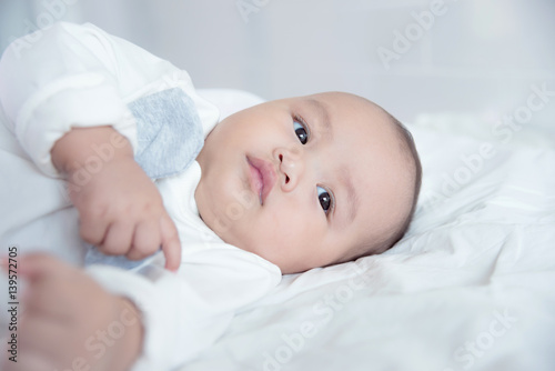 Little asian child lying on bed and looking something