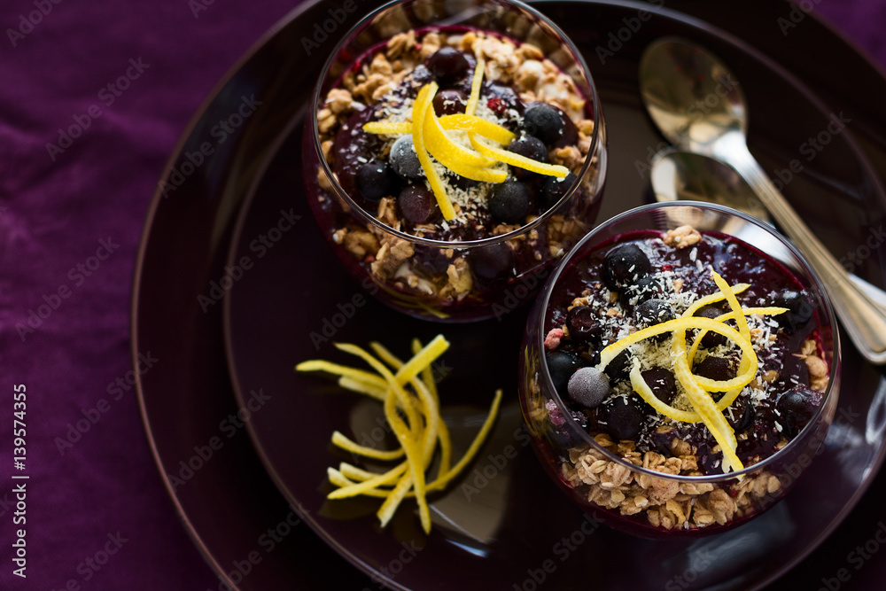 Healthy breakfast: blackberry and banana smoothie with granola on magenta plate. Selective focus Healthy breakfast: blackberry and banana smoothie with granola on magenta plate. Selective focus