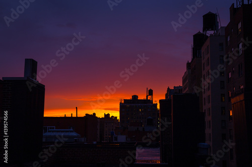 Watching the sun setting on an Upper West Side rooftop, colorful sky, water towers