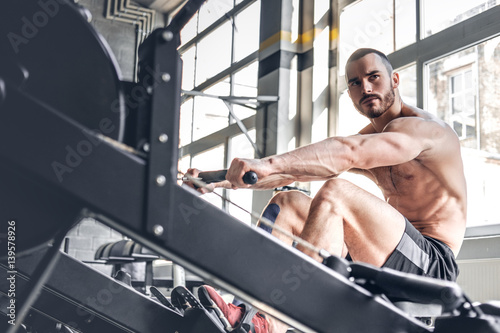 A mandoing workouts on a back with power exercise machine.