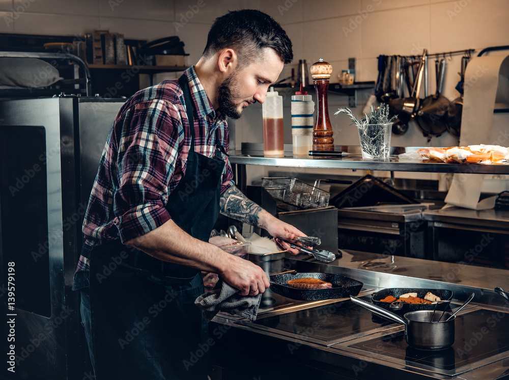 Cheef cook prepairing a meat on a kitchen. Cheef cook prepairing a meat on a kitchen.