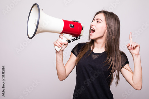 Fényképezés Pretty girl shouting into megaphone on copy space