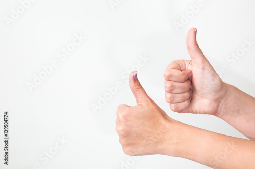 Close up of two female caucasian hands isolated on white background. Young woman shows both hands with thumbs up as sign of success. Horizontal color image. © Andrii Oleksiienko
