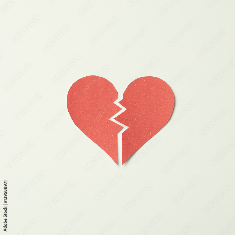 Red paper broken heart on white background