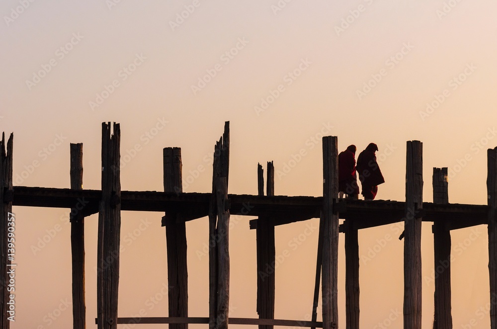Silhouette of monk crossing on the longest bridge in the world, U-Bein Bridge, Mandalay, Myanmar. Silhouette of monk crossing on the longest bridge in the world, U-Bein Bridge, Mandalay, Myanmar.