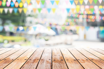 Empty wooden table with party in garden background blurred.