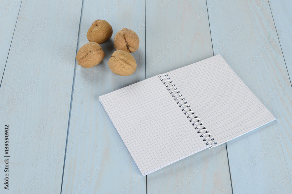 Nueces y libreta sobre fondo de madera azul Stock Photo | Adobe Stock