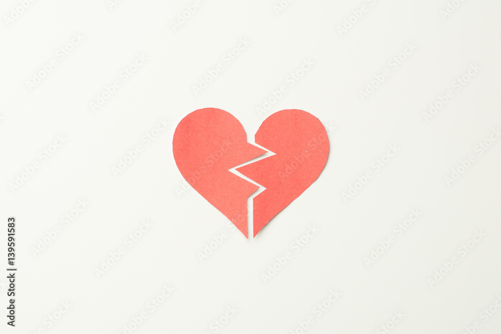 Red paper broken heart on white background