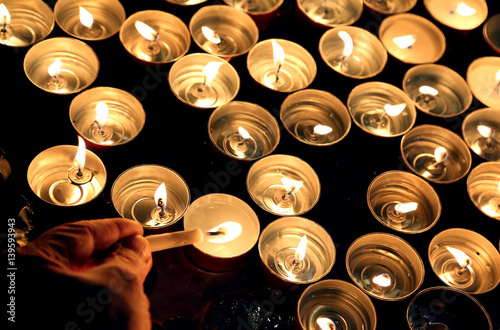 person lights a candle during the religious ceremony