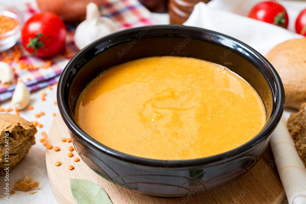 Red lentil cream soup in dark ceramic bowl Red lentil cream soup in dark ceramic bowl