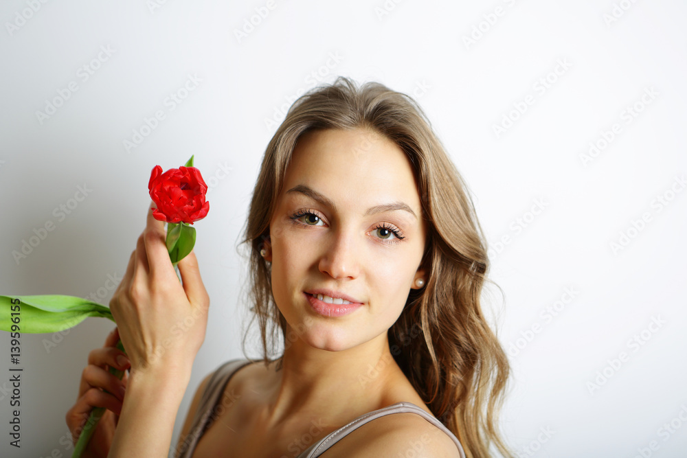 Feminine girl with a red spring flower Feminine girl with a red spring flower