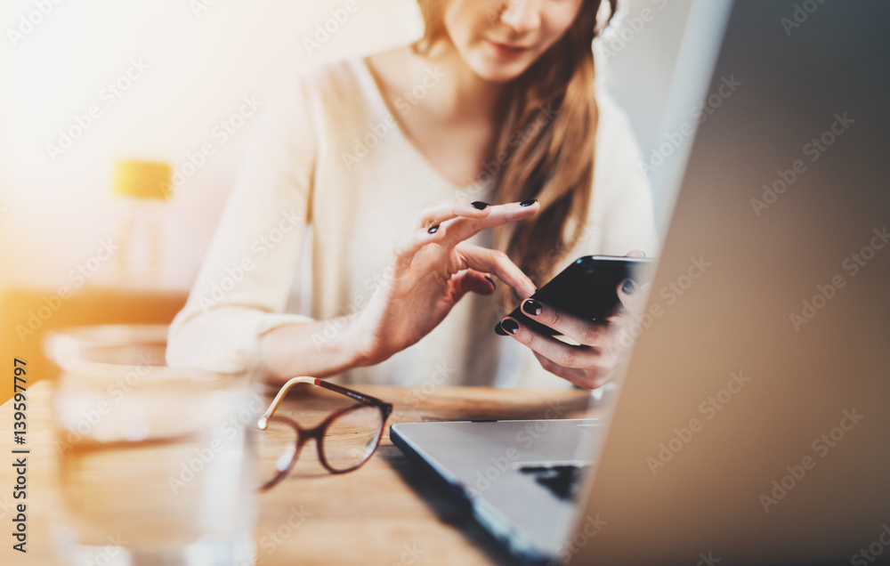 Closeup of young businesswoman working at coffee shop via smartphone and laptop, pretty smiling hipster girl using cellphone at vintage cafe, attractive woman working at home Closeup of young businesswoman working at coffee shop via smartphone and laptop, pretty smiling hipster girl using cellphone at vintage cafe, attractive woman working at home