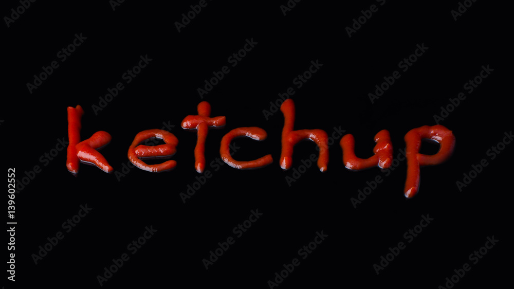 The word ketchup written with ketchup on the black background