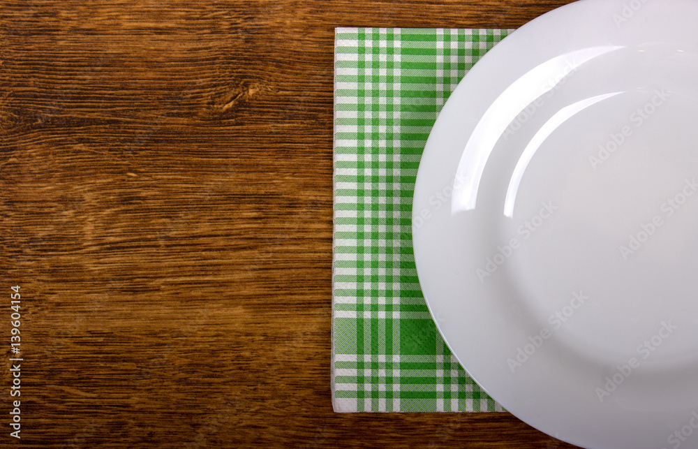 Empty plate and towel on the wooden table background Empty plate and towel on the wooden table background
