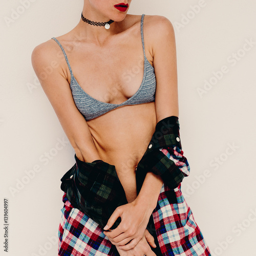 Casual fashion style Model. Bra and checkered shirt. Sensual accessory around the neck Choker