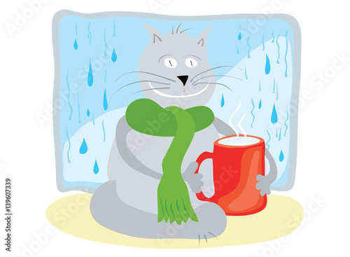 warming atmosphere of home care/ happy cat in a scarf, sitting with a red cup of milk opposite a window with raindrops