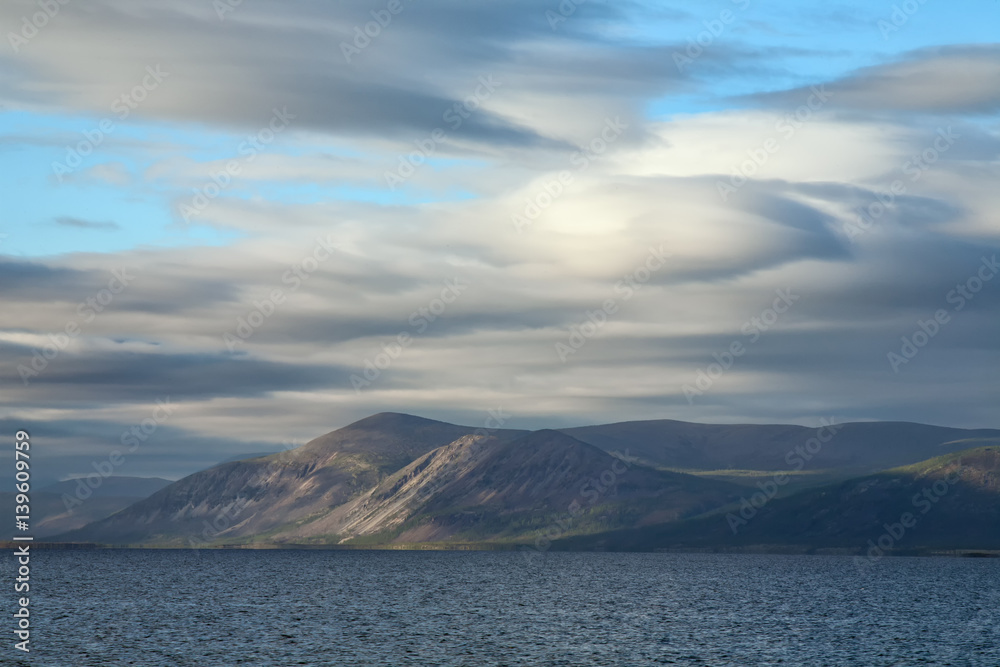 Beautiful clouds over the mountains and lake. Lake Labynkyr. Yakutia. Russia.