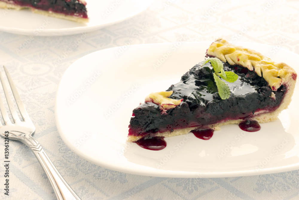 Homemade honeyberry pie in white plate on light cloth napkin Homemade honeyberry pie in white plate on light cloth napkin