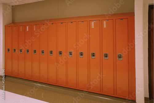 A row of lockers sit quietly in the school hallway