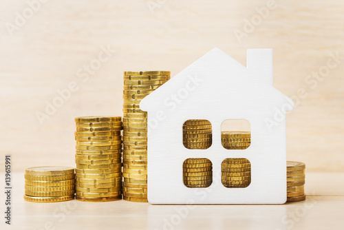 Toy house over Euro coins, mortgage concept photo