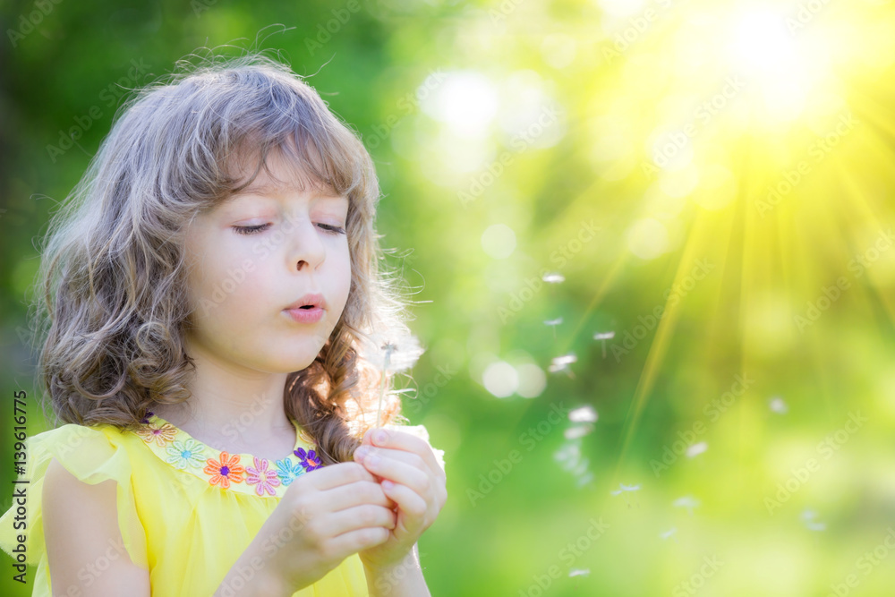Happy child blowing dandelion flower outdoors Happy child blowing dandelion flower outdoors