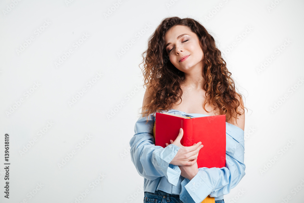 Woman holding book with closed eyes Woman holding book with closed eyes