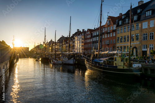 Nyhavn pier at sunset in the Old Town of Copenhagen, Denmark. Nyhavn district is one of the most famous landmark in Copenhagen