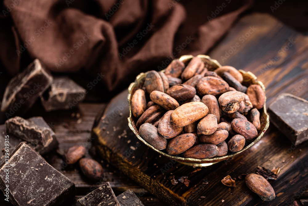 Cocoa beans and chocolate on wooden background Cocoa beans and chocolate on wooden background
