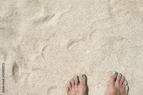 Female feet on white sand. Coral beach by the tropical seaside