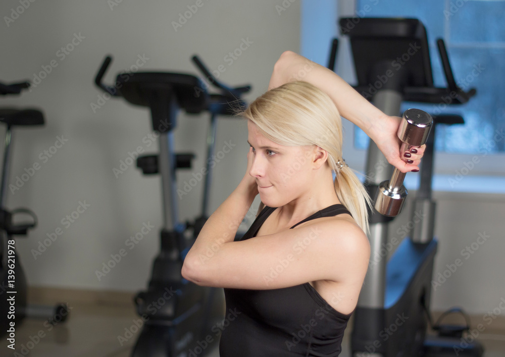 sexy young athletics girl doing dumbbells press exercises. Fitness muscled woman in black sport clothing workout on bench in gym sexy young athletics girl doing dumbbells press exercises. Fitness muscled woman in black sport clothing workout on bench in gym