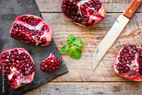 sliced pomegranate on wooden background top view