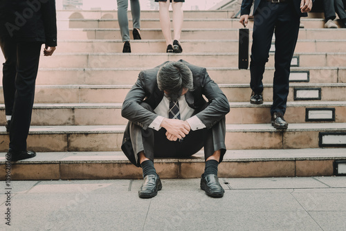 Depressed and tired businessman sitting at stair in city